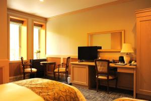 a hotel room with a bed and a desk with a computer at パークホテル九頭竜 in Ōno
