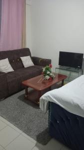 a living room with a couch and a coffee table at Cess cozy studio in Maua