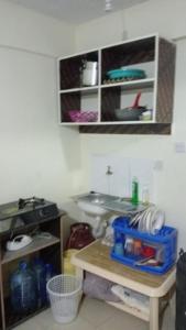 a kitchen with a table and a sink in a room at Cess cozy studio in Maua