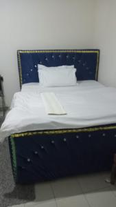 a blue bed with white sheets and pillows at Cess cozy studio in Maua