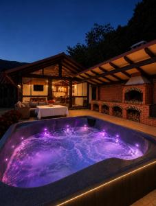 a hot tub with purple lights in a backyard at Rustic Cottage in Sibiu
