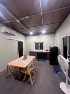 a room with a wooden table and a kitchen at ชนแดนวิวเขา in Chon Daen