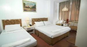 a hotel room with two beds in a room at Hotel Supreme in Baguio