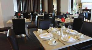 a restaurant with tables and chairs with plates and glasses at Ciriaco Hotel in Rauis