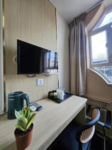 a room with a desk with a tv on a wall at Man Va Hotel in Macau