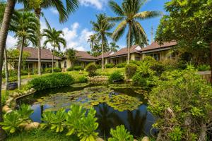 a garden with a pond in front of a house at Silver Beach Resort Ke Ga in Ke Ga