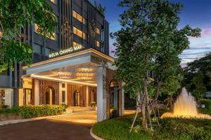 an exterior view of a hotel with a fountain at Meliá Chiang Mai in Chiang Mai