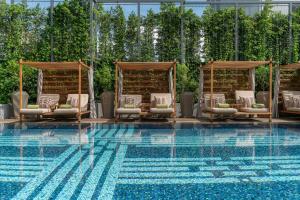 a pool with chaise lounge chairs and a swimming pool at Meliá Chiang Mai in Chiang Mai