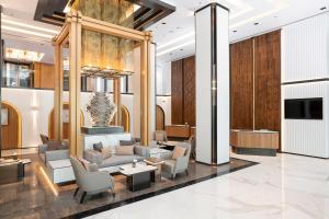 a lobby with couches and chairs and a television at Meliá Chiang Mai in Chiang Mai