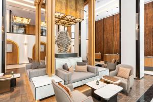 a lobby with couches and chairs and a fireplace at Meliá Chiang Mai in Chiang Mai
