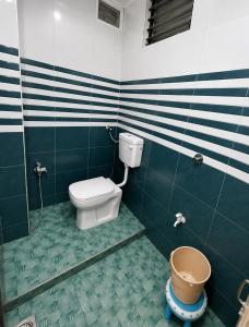 a bathroom with a toilet and a bucket in it at Evergreen Bungalows in Dwarka