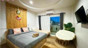 a bedroom with a bed and a television and a chair at Baan Navy Kohlarn in Ko Larn