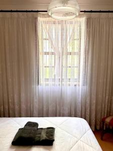 a bedroom with a bed and a large window at Central Home Arouca in Arouca
