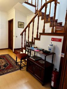 a room with a staircase with a chair and a table at Central Home Arouca in Arouca