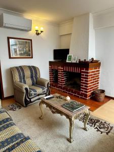 a living room with a fireplace and a coffee table at Central Home Arouca in Arouca