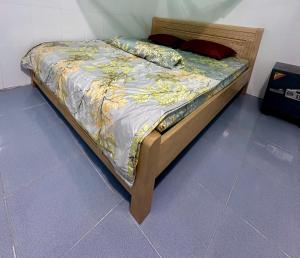 a bed with a wooden frame in a room at Que Nha Homestay in Ấp Chợ (2) +8 photos