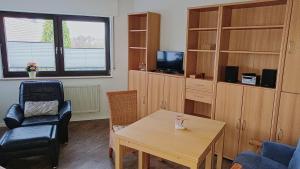 a living room with a table and a chair at Dümmer Refugium - Ferienwohnung in Lembruch