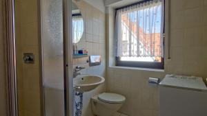 a bathroom with a toilet and a sink and a window at Dümmer Refugium - Ferienwohnung in Lembruch