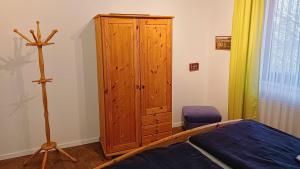 a bedroom with a wooden cabinet and a bed at Dümmer Refugium - Ferienwohnung in Lembruch