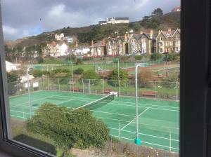 a tennis court with houses in the background at Llwynygog Guest House in Aberystwyth