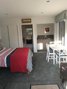 a bedroom with a bed and a table and chairs at hawea river retreat in Albert Town