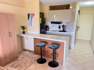 a kitchen with two stools at a kitchen counter at Exclusiva suite en Hotel Marbellamar in Pampatar