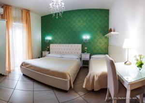 1 dormitorio con 2 camas y pared verde en Blu Mediterraneo B&B, en Messina