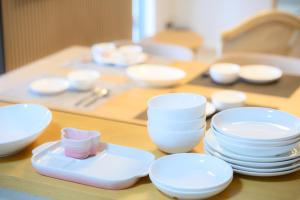 a table with white bowls and plates on it at Villa UMMINA in Tahara +26 photos