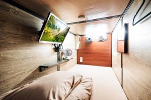 a room with a flat screen tv on a wall at Anshin oyado Tokyo Woman Shinjuku Ogikubo in Tokyo