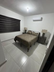 a bedroom with a bed and two lamps on a tiled floor at TadeoHouse in Tijuana