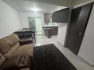 a living room with a brown couch and a kitchen at TadeoHouse in Tijuana +4 photos