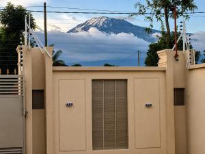 a building with a mountain in the background at Pristine Stays in Moshi