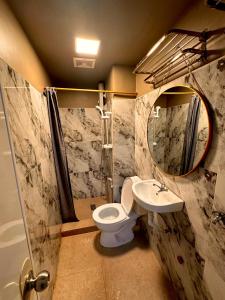 a bathroom with a toilet and a sink and a mirror at 2BR Burnham Hill Condominium in Baguio +15 photos