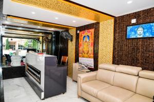a living room with a couch and a television at Hotel Amaravathi Grand in Vijayawāda