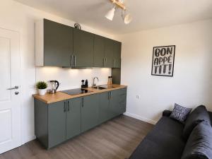 a kitchen with green cabinets and a couch in a room at Garden Haus Livno in Livno
