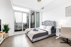 a bedroom with a bed and large windows at Filmores Hotel in Toronto