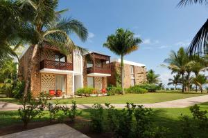 a house with palm trees and a sidewalk at Meliá Zanzibar in Kiwengwa