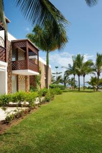 a house with a balcony and palm trees at Meliá Zanzibar in Kiwengwa