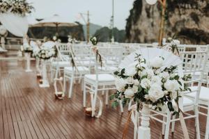 a row of white chairs with flowers on them at The Au Co Cruise - Longest Cruise 2 Bays in Ha Long