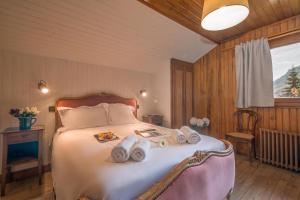 a bedroom with a bed with towels on it at MontBlanc Alpine Ski & Sauna Retreat - Happy Rentals in Le Tour