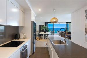 a kitchen with a sink and a counter top at Boardwalk Burleigh Beach - Official in Gold Coast