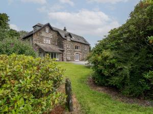 an old stone house with bushes in front of it at High Spy in Keswick