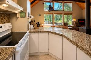 a kitchen with white cabinets and granite counter tops at Icicle Chalet in Leavenworth +45 photos