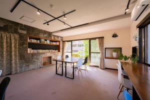 a dining room with a table and chairs and a fireplace at guesthouse LAPPY in Ureshino