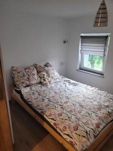 a bed with a teddy bear on it in a bedroom at Bobrowe zacisze in Wleń