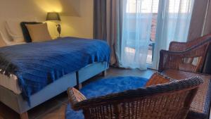 a bedroom with a bed and two chairs and a window at Gryfon Dom in Jastarnia