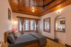 a bedroom with a bed with a wooden ceiling at Blume House- 4BHK Holiday Home with Kitchen & Garden in Srinagar