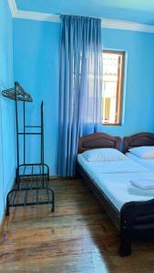 a bedroom with two beds with blue walls and a window at Sea Breeze House Ureki in Ozurgetʼi