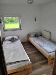 two beds in a room with a window at Bobrowe Zacisze in Wleń