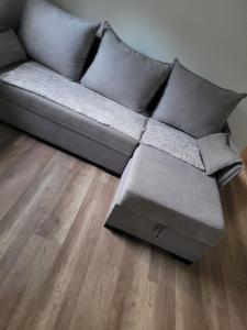 a gray couch in a living room with a wooden floor at Bobrowe Zacisze in Wleń
